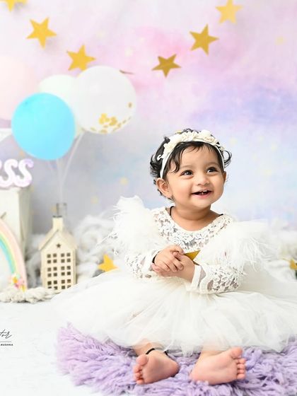 A joyful smile that lights up the room. This little princess is clapping her hands with glee during her magical, pastel-themed birthday shoot.