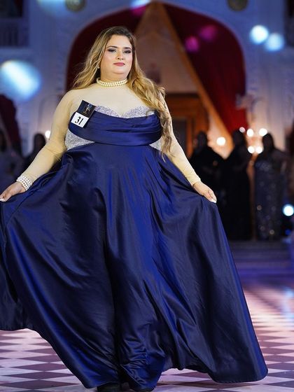 The royal blue satin plus-size gown, showing its full volume and grace on the runway.