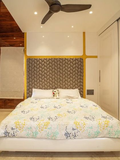 The master bedroom in this penthouse features a unique braided headboard and a calm, neutral color palette for a comfortable and stylish retreat.