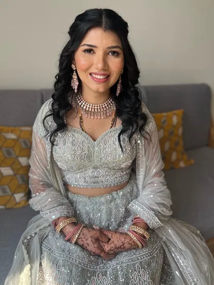 A beautiful bride ready for her reception. The makeup is soft and romantic, with a focus on her radiant smile.