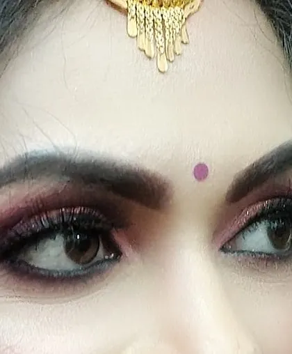 It's all in the details. This close-up shows a deep pink and gold smokey eye with full lashes, designed to make the eyes pop for a traditional wedding ceremony.