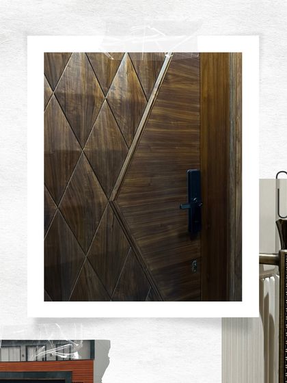 A close-up look at a custom veneer door with a geometric diamond pattern. The high-gloss finish highlights the natural grain of the wood, creating a dynamic and luxurious surface.