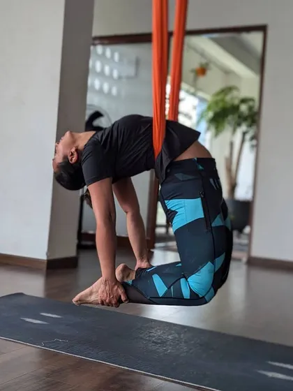 Using the hammock to achieve a deep, supported backbend. This variation of Ustrasana (Camel Pose) allows for greater opening through the chest and shoulders.