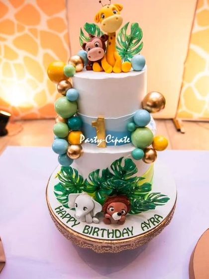 The cake for Ayra's safari party was a masterpiece, adorned with cute, edible jungle animals and tropical leaves.