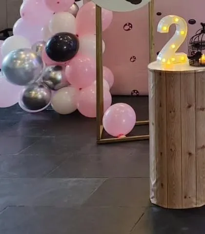 A light-up number '2' on a wood-effect pedestal, part of the panda party decor.