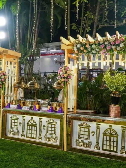 An example of our elegant outdoor catering setup. Featuring our white and gold counters, floral arrangements, and premium serveware, we design a food display that perfectly complements the theme of your event.