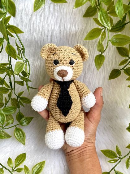 A classic teddy bear, a timeless gift for any age. This one is shown with a red ribbon, a black tie for 'Daddy Bear', and with expressive green eyes. They are soft, cuddly, and made to be loved.