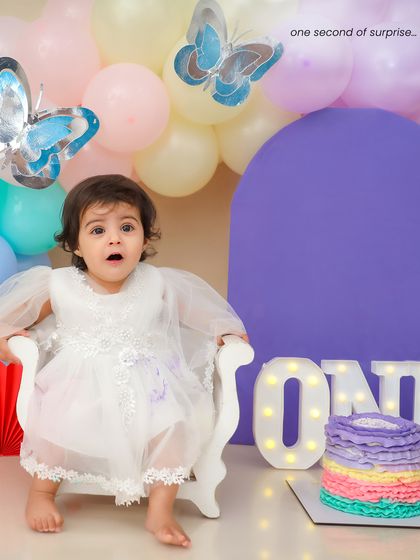 The moment of pure surprise when she sees her birthday cake. Capturing these fleeting expressions is what makes cake smash sessions so special.