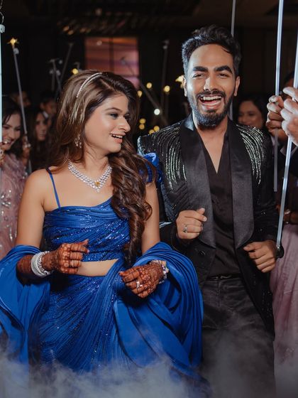 The bride and groom making a grand entrance. Her makeup is designed to be seen and admired from afar.