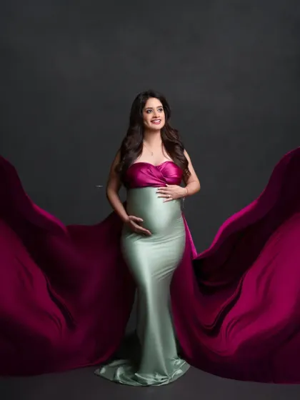 A unique and fashionable choice. This dual-toned gown, with a magenta top and mint green bottom, features dramatic flowing fabric for a bold and artistic statement.