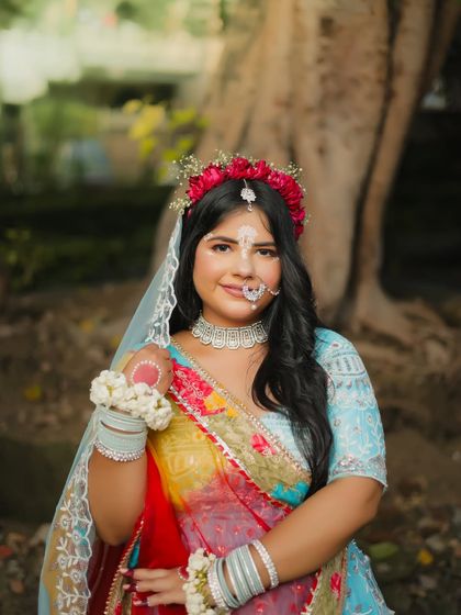 A solo portrait of the Radha look, with a focus on her soft makeup and floral jewelry.