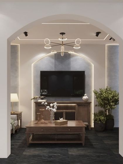 An arched entryway elegantly frames the view into this cozy media room. The design features built-in display shelves on either side, creating a beautiful and symmetrical transition that adds architectural interest to the home.