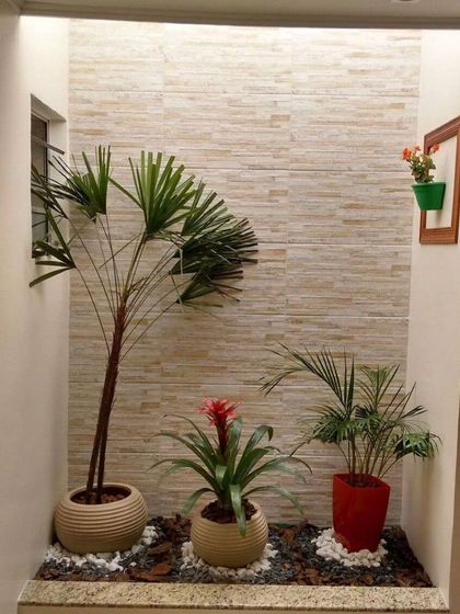 This indoor niche was transformed into a mini garden. We used a textured stone tile for the back wall and arranged a variety of plants in stylish ceramic pots on a bed of pebbles, creating a beautiful, low-maintenance feature.