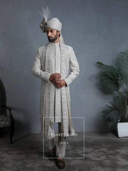 Woven in patience, this ivory paneled sherwani features Mughal-inspired vines created with resham threads, zari artistry, and zardozi details, perfect for a groom's grand entrance.