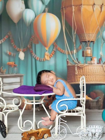 After a long flight, it's time for a nap. This newborn is sleeping peacefully at a tiny table in our hot air balloon world.