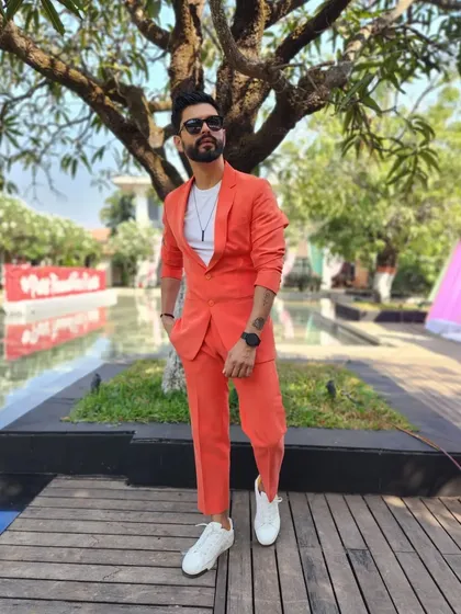 A vibrant orange suit, perfect for a fun, outdoor carnival or mehendi event.