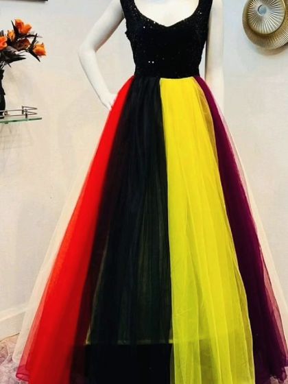 This fun and colorful gown features a black sequin bodice and a multi-colored tulle skirt. It's a great rental choice for a vibrant party or a creative photoshoot.