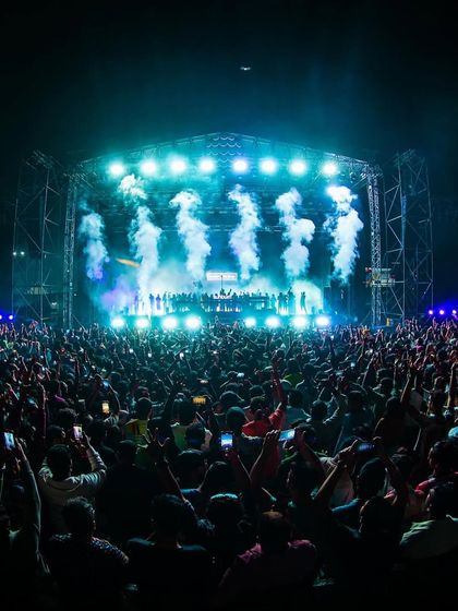 A fish-eye lens captures the immense scale of the crowd and stage for Armin van Buuren, with smoke cannons firing in unison.