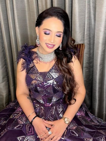A stunning engagement bride in a dazzling purple gown. The makeup features a pop of purple on the eyes to tie the whole look together, creating a bold yet elegant statement.