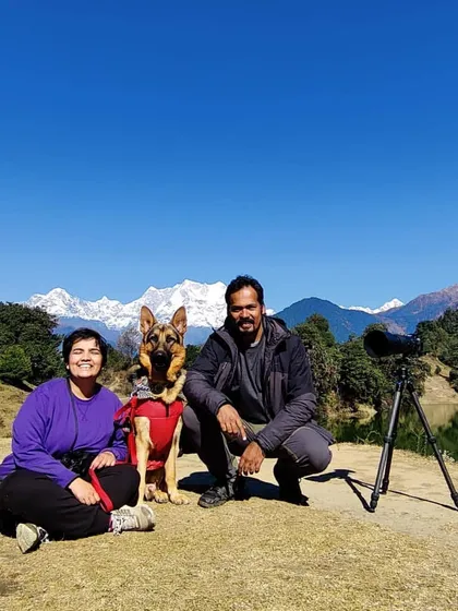 A family portrait, our style. Here we are on a beautiful day in Chopta, taking a break during a hike with our German Shepherd, Jiraiya. The snow-capped Himalayan peaks in the background made for an epic memory.