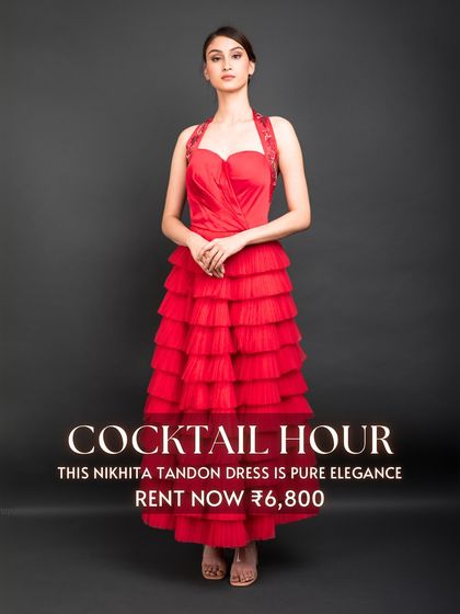 The 'Cocktail Hour' calls for pure elegance, like this red tiered dress by Nikhita Tandon. Its vibrant color and flattering silhouette make it a perfect rental for a glamorous evening party.