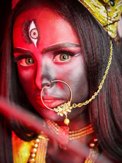 A striking close-up of a goddess look, with a third eye and intense, fiery red lighting.