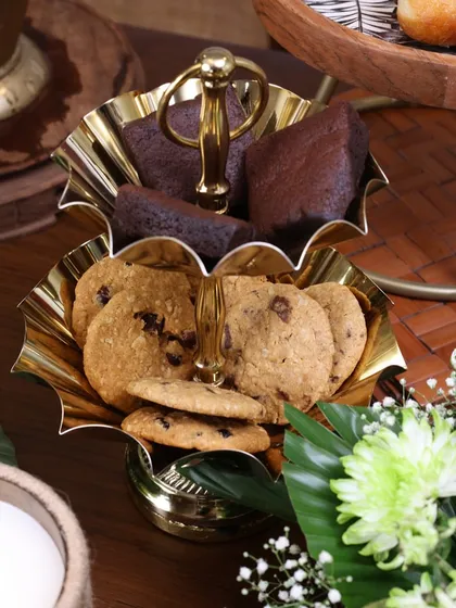 Our two-tiered gold stand with scalloped, flower-like bowls. It’s a beautiful and functional piece for serving cookies, brownies, or other small bites during a high tea or festive gathering.