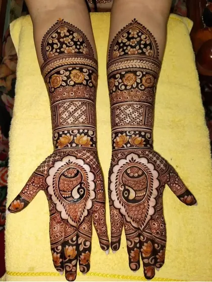 This design features a central paisley motif on the palm, surrounded by delicate floral patterns. The arms have a classic look with bands of flowers and geometric checks.