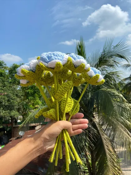 A side view of the light blue rose bouquet, showing the detailed green stems and leaves.