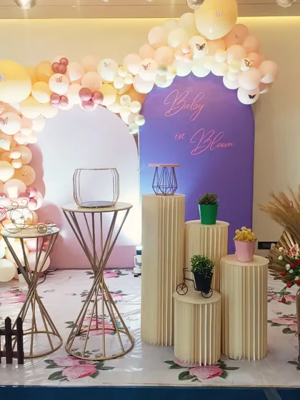 A beautiful 'Baby in Bloom' shower theme with a butterfly balloon arch and boho elements like pampas grass.