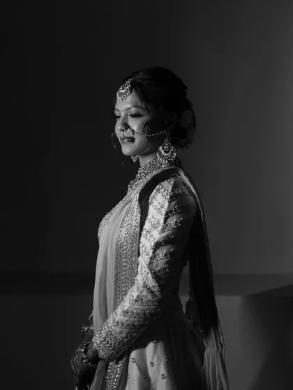 A timeless black and white portrait of the bride. This artistic shot highlights the beautiful structure and soft glam makeup, proving that a great look is stunning in any light.