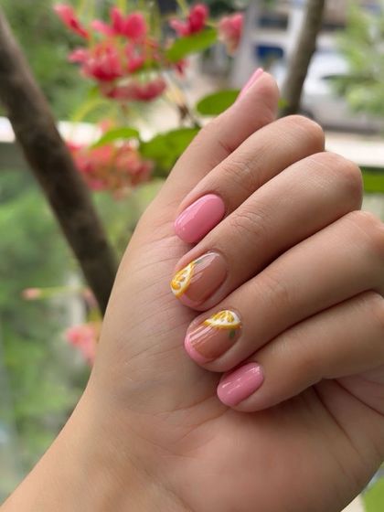 A fun and fruity design with pink polish and accent nails featuring hand-painted lemon slices.