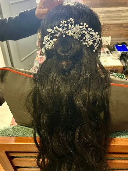 A chic and elegant half-up, half-down hairstyle. The look is finished with a beautiful pearl hair accessory, making it perfect for a sangeet or reception.