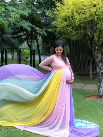 The rainbow gown in motion. The flowing pastel fabric creates a beautiful arc in this dynamic outdoor shot, highlighting the grace and beauty of pregnancy.