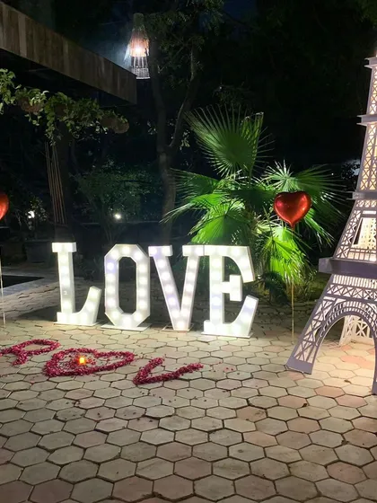 For a truly grand romantic gesture, we offer unique props like this illuminated Eiffel Tower replica. Paired with large light-up "LOVE" letters and a heart made of rose petals, this outdoor setup creates a magical, Parisian-inspired atmosphere.