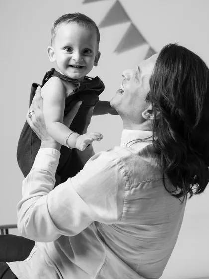 The pure joy of a father lifting his baby high. This black and white shot freezes a perfect moment of laughter and connection.