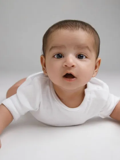 A classic tummy time pose, showing off those beautiful, curious eyes. This is a great way to capture their features at this age.