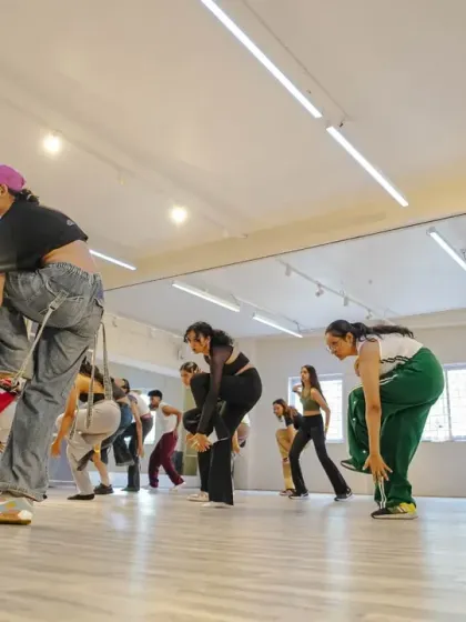 Students practicing their waacking poses and drills, focusing on the sharp, dramatic movements of the style.