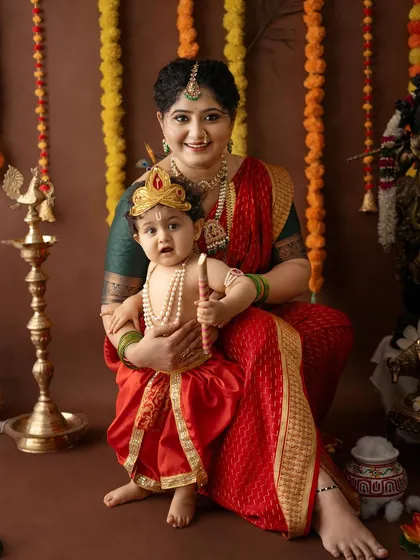 A classic portrait of a mother and her son in their full Janmashtami costumes, capturing a beautiful memory.