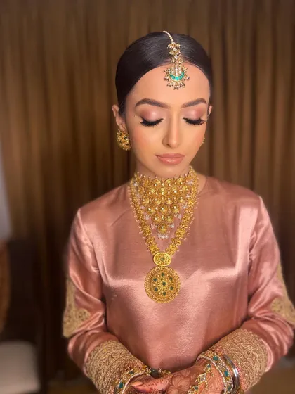 A close-up of Pawlin's Anand Karaj makeup, with her eyes closed to show the soft, neutral eyeshadow and flawless skin.