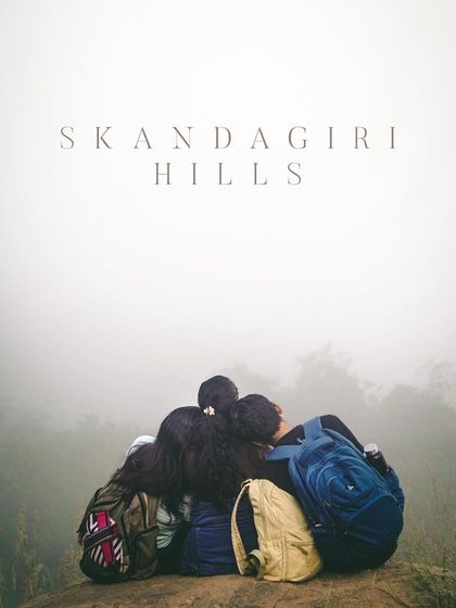 A group of friends huddled together on a misty morning at Skandagiri Hills, a popular sunrise trek near Bangalore.