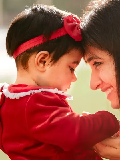 Forehead to forehead, sharing a special bond. This is a classic and timeless mother-daughter portrait.