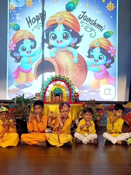 A group of our "little Kanhas" poses on stage during the Janmashtami celebration. Dressing up in traditional costumes helps students connect with the cultural significance of the festival in a fun and memorable way.