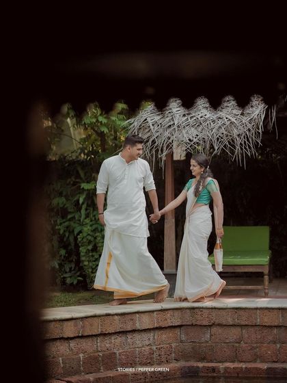 A romantic shot of the couple walking hand-in-hand, framed by the architecture of the building.