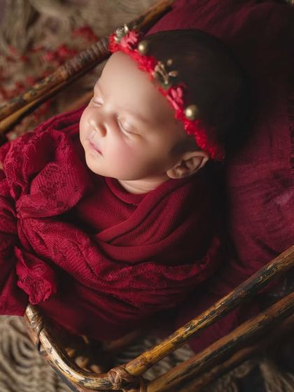A closer shot within the basket, focusing on the baby's serene expression and the rich colour of the swaddle.