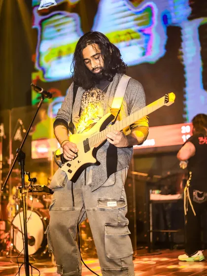 Our guitarist delivering a powerful performance, completely lost in the sound of his instrument.
