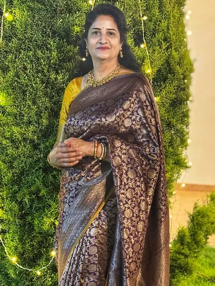 Our client Lavanya Reddy radiates regal charm in this exquisite handwoven Banarasi silk saree with a rich chocolate brown body and a contrasting mustard yellow blouse.