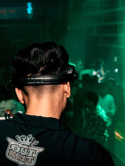 A close-up shot from behind, showing my focus on the music and the crowd. The green laser beam cuts through the darkness, adding to the club's atmosphere.