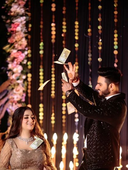 A fun and celebratory moment as the groom showers money on the dance floor. This candid shot is full of energy, laughter, and the uninhibited joy of the celebration.
