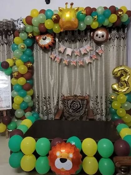 A jungle animal theme for a 3rd birthday, with a balloon arch, animal-shaped foil balloons, and a simple backdrop.